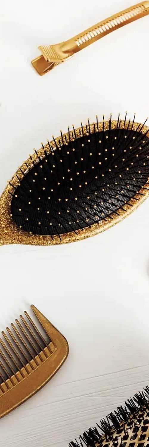 Golden hairbrush and comb on a white background.